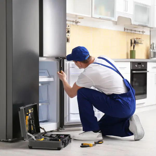 A technician repairing a refrigerator